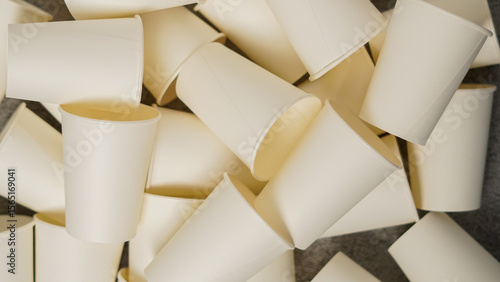 Pile of white disposable paper cups. Eco-friendly, single-use beverage containers for coffee, tea, or water, top view.