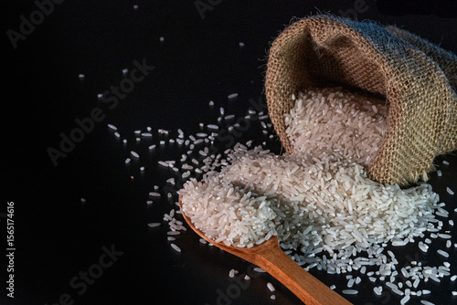 Wallpaper Mural White rice spilling from a burlap sack onto a dark surface, with black background Torontodigital.ca