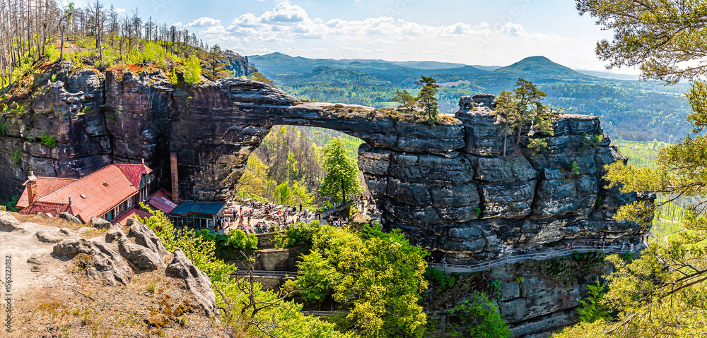 Fototapeta premium A view past trees towards the Pravcicka Gate arch in springtime