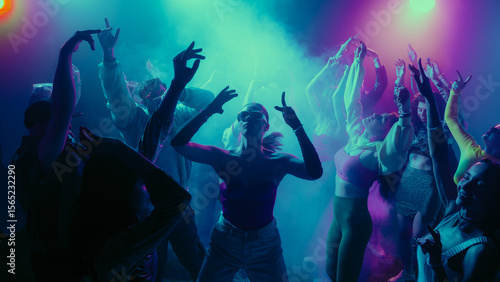 Photos A vibrant party scene with diverse people dancing under colorful lights