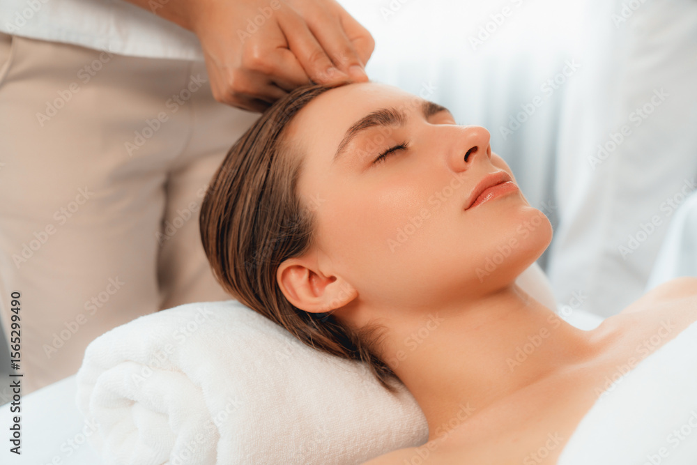 Caucasian woman enjoying relaxing anti-stress head massage and pampering facial beauty skin recreation leisure in dayspa modern light ambient at luxury resort or hotel spa salon. Quiescent Caucasian woman enjoying relaxing anti-stress head massage and pampering facial beauty skin recreation leisure in dayspa modern light ambient at luxury resort or hotel spa salon. Quiescent
