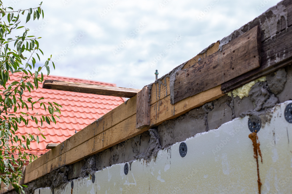 Concrete wall with wooden formwork on top, construction of reinforced concrete belt, wall repair, preparation for installation of maurlat Concrete wall with wooden formwork on top, construction of reinforced concrete belt, wall repair, preparation for installation of maurlat