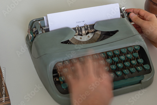фотографія Hands are quickly typing dream big On a vintage typewriter with round green keys