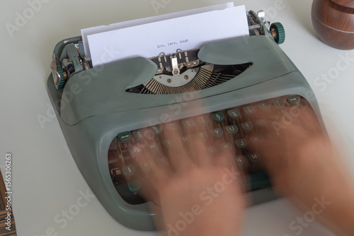 Hands typing quickly on a vintage typewriter, creating a motion blur effect, with the words live, love, laugh already typed on the paper, suggesting creative writing or storytelling