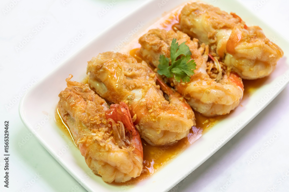 Delicious golden-brown fried prawns served on a white plate, garnished with cilantro, perfect for seafood lovers. Delicious golden-brown fried prawns served on a white plate, garnished with cilantro, perfect for seafood lovers.