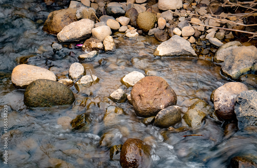Obraz premium Small stones of various sizes are in the middle of the river flow