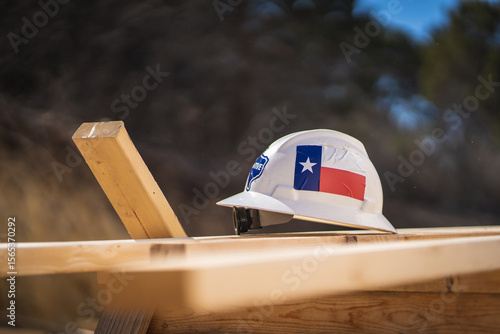 фотографія Texas Flag Sticker on Construction Hard Hat Sitting on Wooden Board Planks at Co