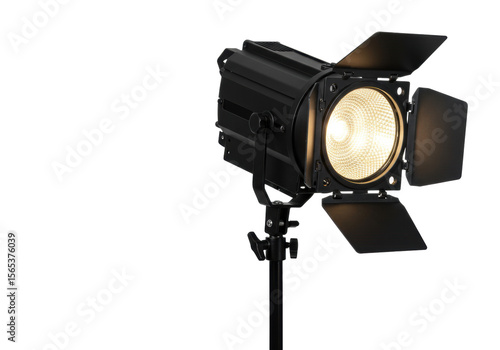 A black metallic studio Fresnel spotlight with open barn doors emitting bright warm white light on a black stand, isolated against a clean transparent studio background with copy space,