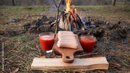 Banquet by the campfire: sausages and tomato juice