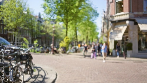 Wallpaper Mural Blurred european city scene with people walking outside, bicycles parked, trees lined up, sunny day, urban feel, showcasing relaxed, outdoor lifestyle in blurry focus. Torontodigital.ca