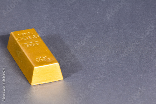 A shiny 999.9 fine gold bar on a sleek dark surface, symbolizing wealth and investment. Ideal for financial and luxury themes