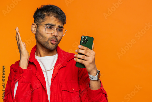 Fotografie Upset sad Indian man use smartphone typing browsing, play game loses surprised by sudden lottery results bad fortune loss fail unlucky news
