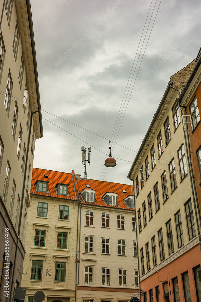 Obraz premium Living houses with red roofs in the center of the Copenhagen on a gloomy day 