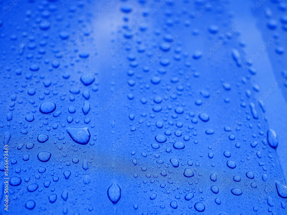 The image is of a blue surface with many small drops of water on it. The drops are scattered all over the surface, creating a sense of movement and energy. Background for design with rich color The image is of a blue surface with many small drops of water on it. The drops are scattered all over the surface, creating a sense of movement and energy. Background for design with rich color