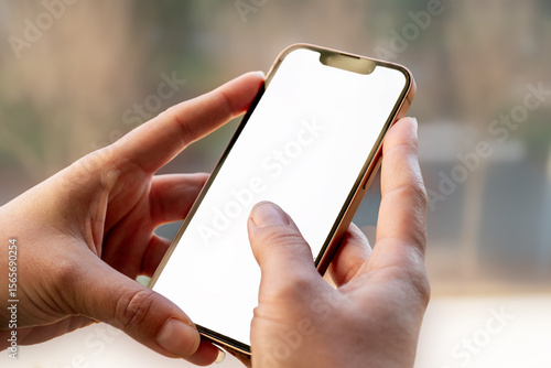 Obraz na płótnie Manos sosteniendo un smartphone moderno con pantalla blanca, listo para insertar contenido