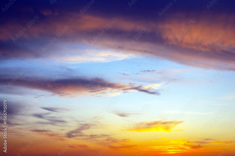 Obraz premium Dramatic evening sky filled with heavy storm clouds and patches of golden light. The interplay of shadows and illuminated areas adds depth and mystery to the scene