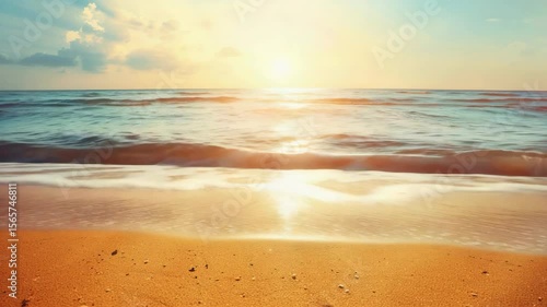 A serene beach scene at sunset with gentle waves lapping the shore.