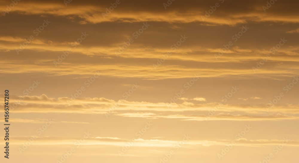 Fototapeta premium Serene cloudscape at sunrise showcasing soft golden hues and gentle gradients