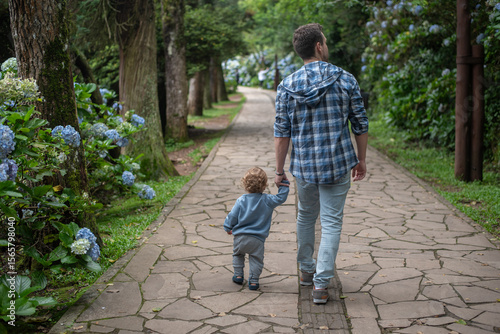 Father and baby son taking a walk on a path at Lago Negro - Gramado - Rio Grande do Sul - Brazil
