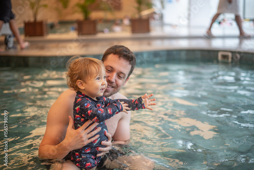 Father and baby son having fun in a kiddie pool