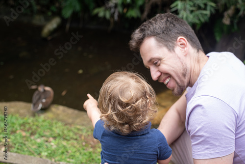 Baby showing a duck to his father