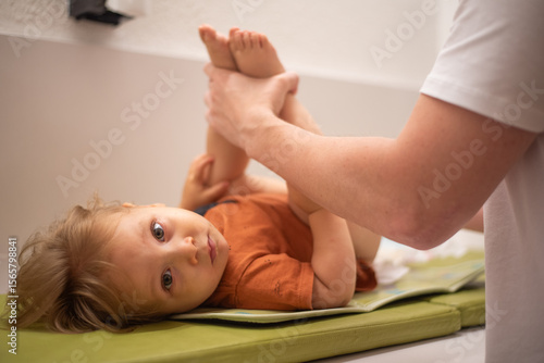 Father changing his 16-month-old son's diaper