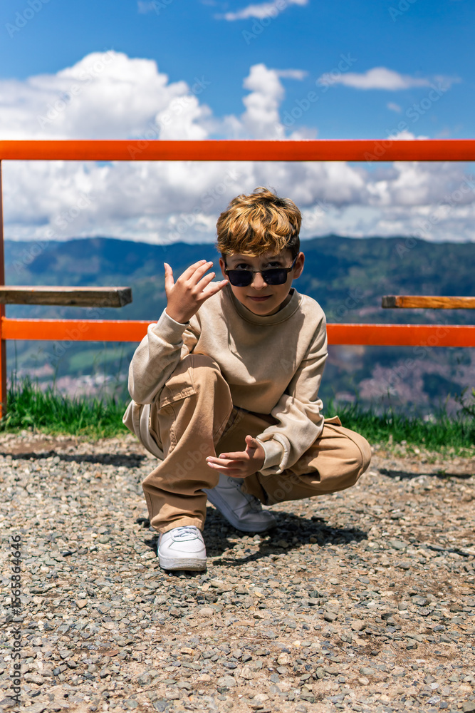 Obraz premium Smiling Colombian boy in a natural setting, concept of childhood, diversity and emotional connection.