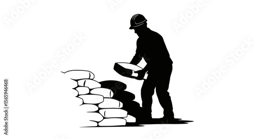 Silhouette of a construction worker building a wall with sandbags, wearing a hard hat.