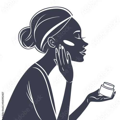 Elegant woman applying facial cream to her cheek with a jar of moisturizer in her hand