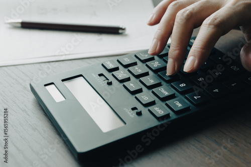 黒い計算機で計算をする女性の手元　家計　経理　見積り　予算　費用　節約