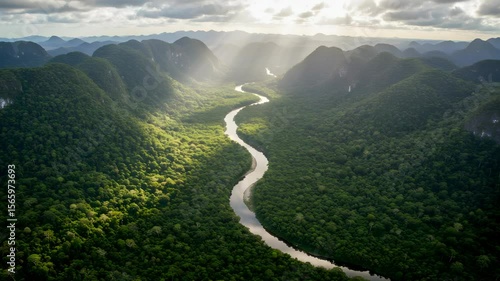 Lush Green Valley River Winding Through Hillsides and Sunlight Breaking Through Cloudscape