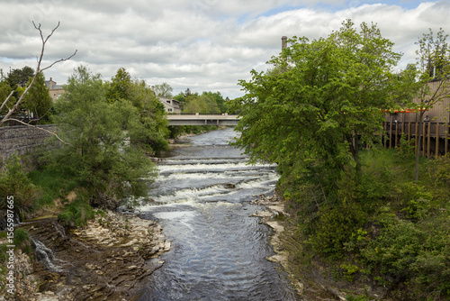 Fergus - town in Ontario on the Grand River, popular tourist town with beautiful old stone houses, a waterfall, and ancient bridges. A tourist magnet. Summer sunny day with cloudy sky. Ontario, Canada