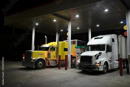 Photography Two trucks from different eras refueling at gas station