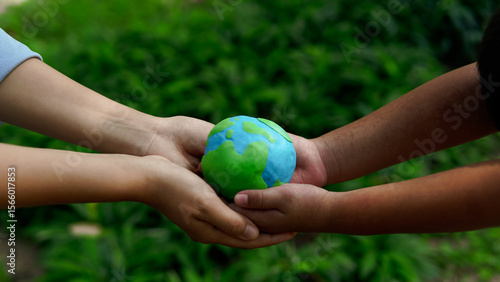 Hands holding green earth together on nature background for the Sustainable Development Goals. Responsibility for the environment.Global community teamwork. Ecosystem. Save world.