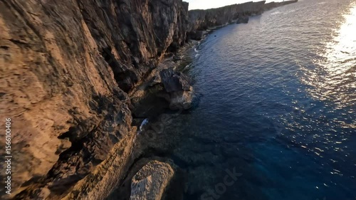 Bird's eye view of flying above beautiful sea and cliff in Okinawa at the sunset