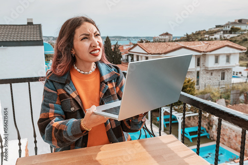 Vászonkép Young frustrated woman working remotely on laptop, squinting from weak signal an