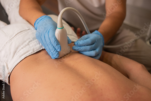 Professional therapist is giving a massage with a machine on the patient back