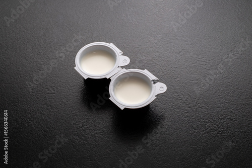 Small milk, coffee creamer pots on red. Mono portions, for catering etc.
Coffee creamer.
Single portion pots of UHT milk for coffee.