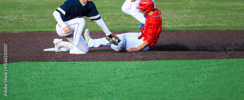 Obraz na płótnie Runner Sliding into Second Base with the Short Stop Trying to Apply the Tag Duri