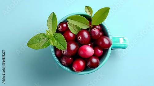 Wallpaper Mural Blue cup filled with red berries and green leaves. The berries are small and round, and the leaves are green and leafy. Concept of freshness and natural beauty Torontodigital.ca