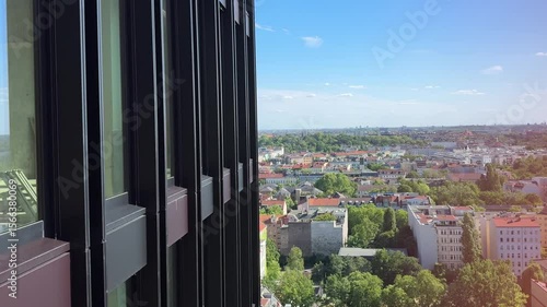 Close-up of a façade descending from a skyscraper with a view of a cityscape in Berlin