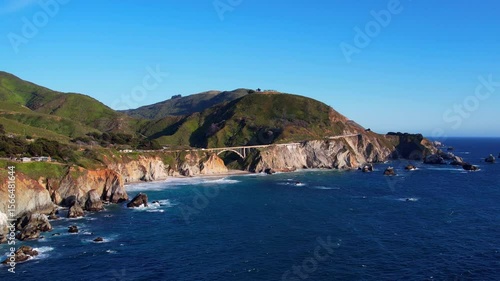 Cinematic aerial drone footage of Bixby Creek Bridge along the Pacific Coast Highway in Big Sur, California. Captured in 4K resolution during golden hour, the iconic bridge with ocean cliffs USA