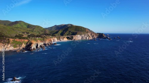 Cinematic aerial drone footage of Bixby Creek Bridge along the Pacific Coast Highway in Big Sur, California. Captured in 4K resolution during golden hour, the iconic bridge with ocean cliffs USA