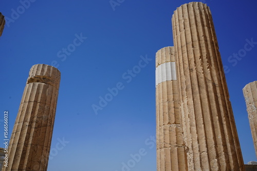 Ancient ruins stand tall against a clear sky, revealing traces of history and marvel in a forgotten realm of stunning architecture in a tranquil landscape