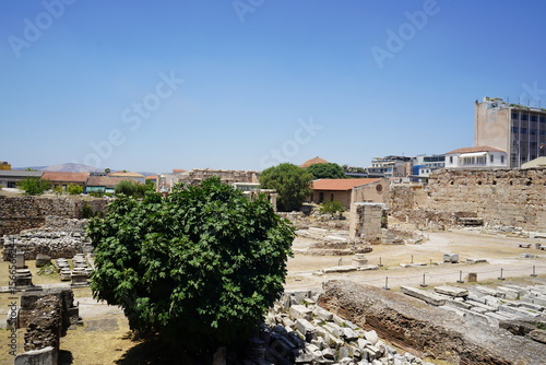 Exploring ancient ruins under a bright blue sky in Greece, where history whispers through the weathered stones and vibrant greenery thrives amidst the remnants of time