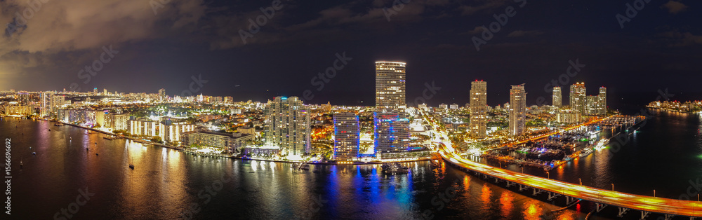 Fototapeta premium Aerial view of night South Beach coastline. Miami skyline with tropical blue waters panorama. Panorama over the Miami skyscrapers at dusk.
