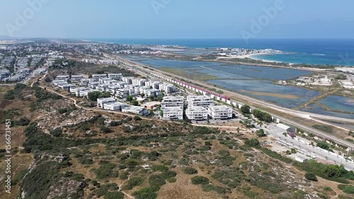 Aerial footage of Atlit a coastal town located south of Haifa, view with salty ponds and red train moving towards to Tel Aviv, Israel, Mediterranean sea