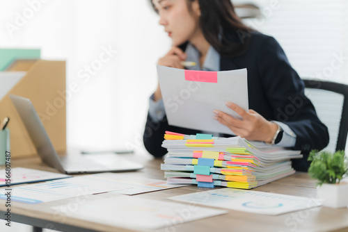 Focused Analyst: A professional is deeply immersed in their work, meticulously reviewing documents at a desk, epitomizing concentration and the dedication to a job well done. 