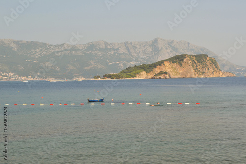 Idyllic Sveti Nikola Island (Hawaii Beach) in Budva, Montenegro, with Swimmers and Mountain Backdrop