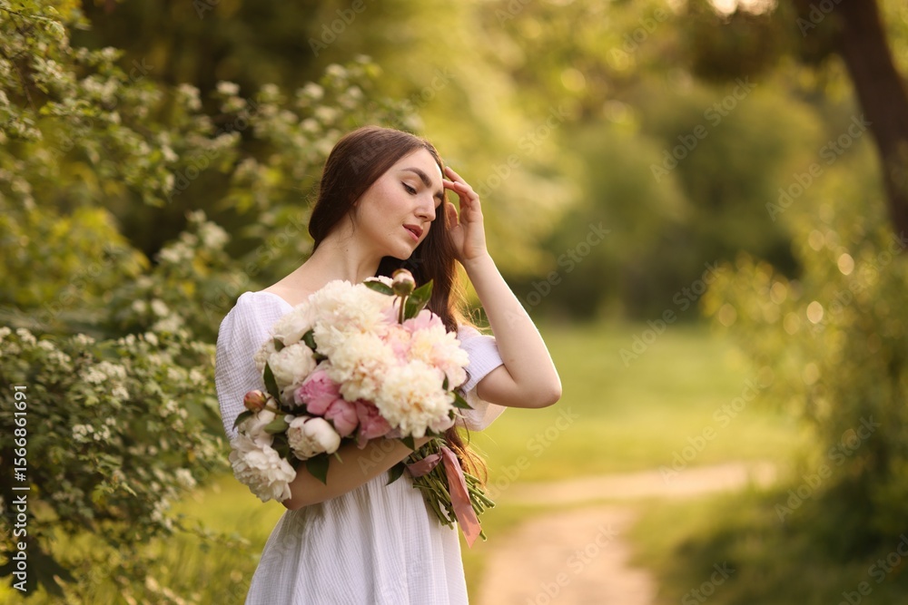 Beautiful woman with bouquet of peonies in park. Space for text Beautiful woman with bouquet of peonies in park. Space for text